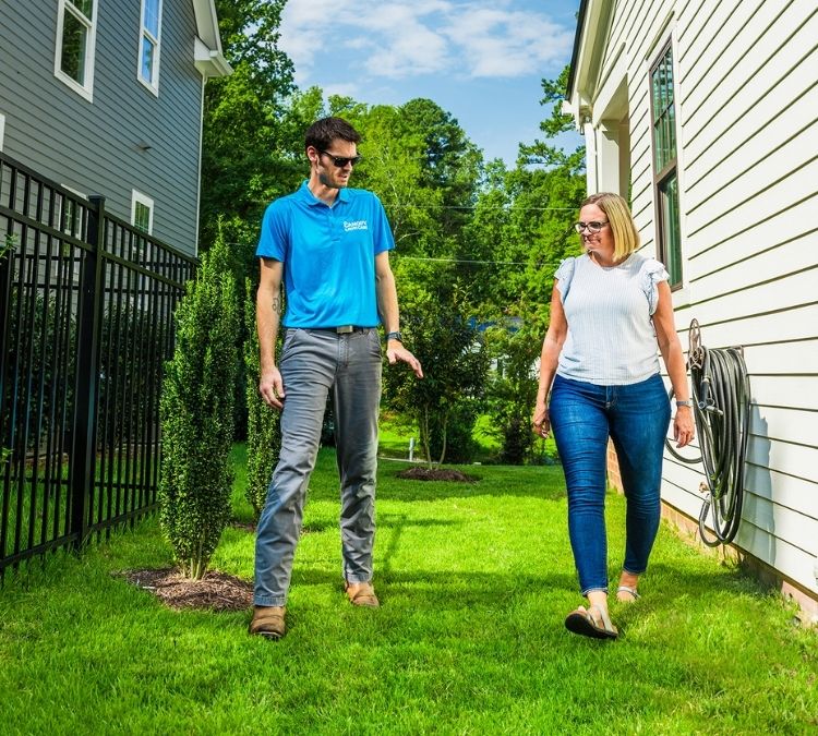 Canopy Lawn Care technician walking a property with a new customer to discuss lawn health and treatment plan